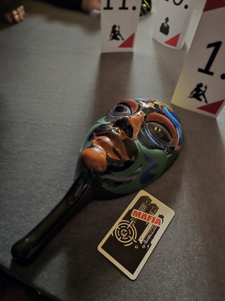 Mafijas maska un spēļu karte uz galda, tēma 