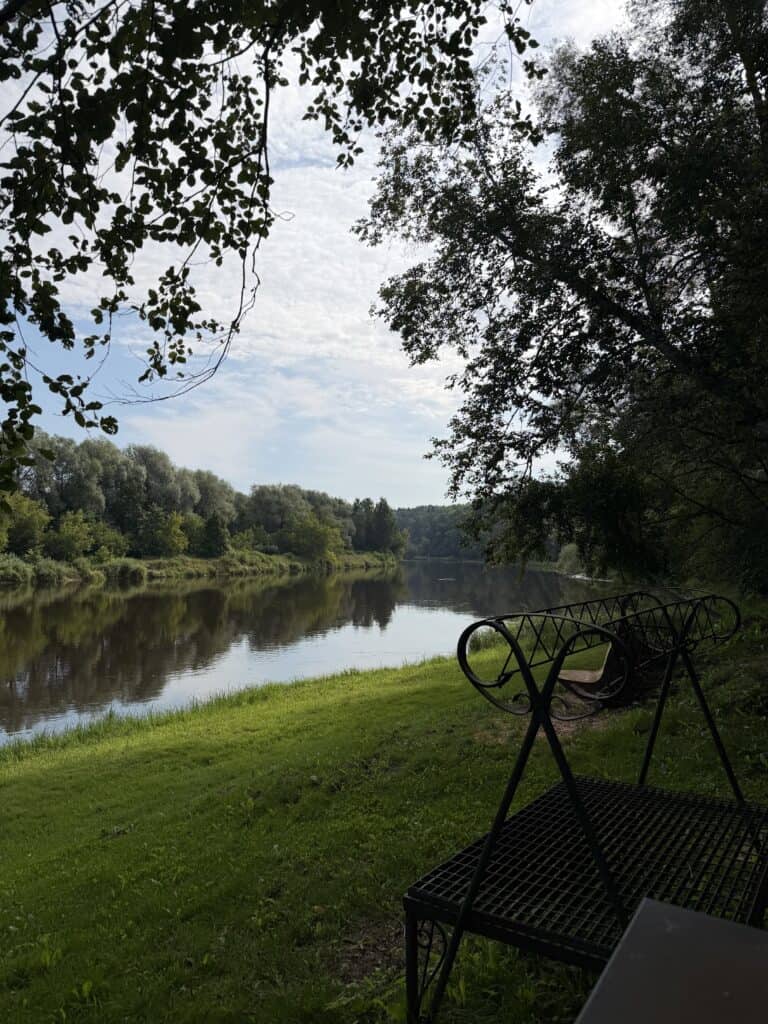 Pikniko vieta su suoliukais ir vaizdu į upę, gamtos peizažas.