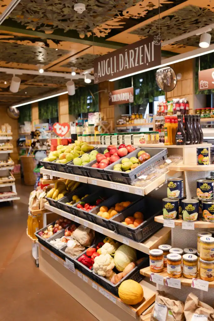 Augļu un dārzeņu veikala plaukti ar svaigiem produktiem.